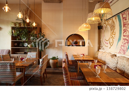 Fashionable bohemian dining zone featuring mural and lush greens Fashionable bohemian dining zone featuring mural and lush greens 138729802