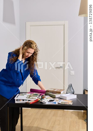 Female curator assesses and organizes photographs for upcoming exhibit 138729896