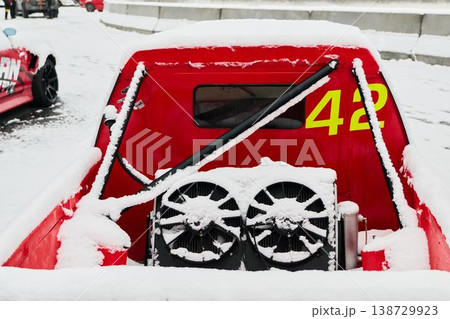 Snowcovered pickup showcasing racing decals and industrial setting Snowcovered pickup showcasing racing decals and industrial setting 138729923