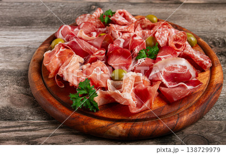 Assortment , sliced meat appetizer, prosciutto, salami and ham, with olives, on a wooden board, breakfast, top view, close-up, no people, Assortment , sliced meat appetizer, prosciutto, salami and ham, with olives, on a wooden board, breakfast, top view, close-up, no people, 138729979