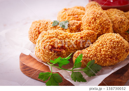 fried chicken legs in breadcrumbs, on a wooden chopping board, with red sauce, no people, fried chicken legs in breadcrumbs, on a wooden chopping board, with red sauce, no people, 138730032