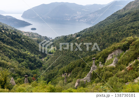 Panoramic view of Pyramids of Zone near Lake Iseo with white hoodoos forested hills calm water Panoramic view of Pyramids of Zone near Lake Iseo with white hoodoos forested hills calm water 138730101