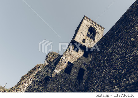 Bell tower and massive castle wall in Cavriana with rugged masonry stark lights film grain mood 138730116