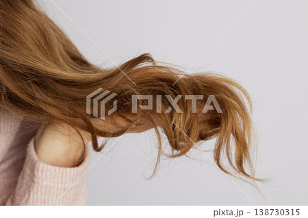 Side Profile of Woman Holding Wavy Hair Texture 138730315