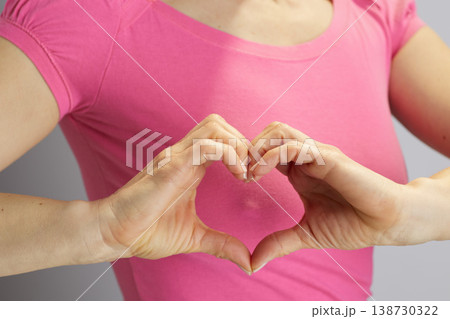 Woman Forming Heart Symbol with Hands at Chest Woman Forming Heart Symbol with Hands at Chest 138730322