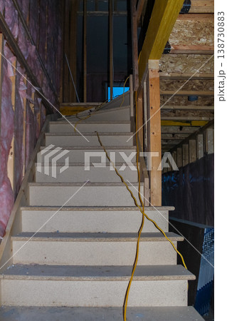 Interior view of unfinished wooden staircase with exposed framing and electrical wiring in a residential construction site Interior view of unfinished wooden staircase with exposed framing and electrical wiring in a residential construction site 138730883