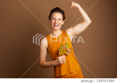 Strong Woman Flexing with Autumn Leaves Strong Woman Flexing with Autumn Leaves 138731389