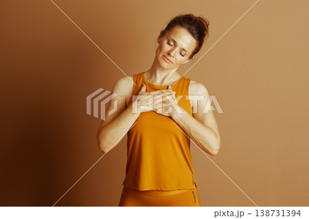 Inner Peace: Woman in Orange Mindful Pose Inner Peace: Woman in Orange Mindful Pose 138731394