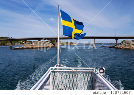 Swedish flag on ferry near bridge between Styrso and Donso islands of Gothenburg archipelago, Gothenburg Minucipality, Vastra Gotaland County, Sweden, sunny day 138731607
