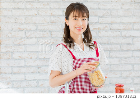 キッチンでパスタ料理を作る若い女性 キッチンでパスタ料理を作る若い女性 138731812