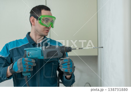 A man drills into a wall.  138731880