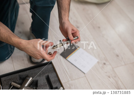 A plumber is replacing a faucet in the kitchen. 138731885