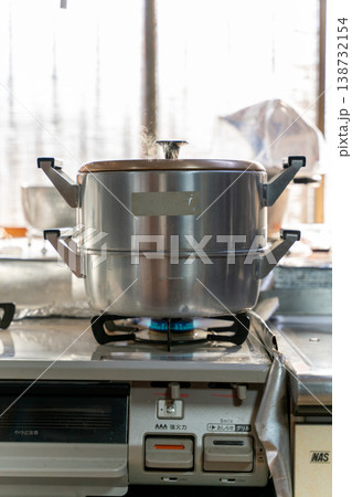湯気立つ蒸し器、キッチンでの調理風景 138732154