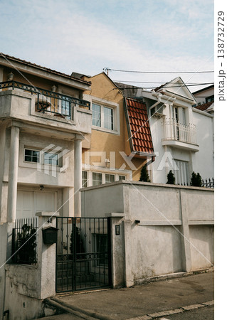 Residential houses with balconies and fence in quiet urban neighborhood under soft daylight. Ideal for real estate, architecture, suburban lifestyle and housing concepts 138732729