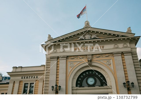 Historic Belgrade railway station facade with Serbian flag, clocks and classical details. Concept of national identity, travel and heritage architecture 138732799