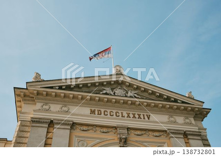 Historic Belgrade railway station facade with Serbian flag and classical details. Concept of national identity, travel and heritage architecture. Historic Belgrade railway station facade with Serbian flag and classical details. Concept of national identity, travel and heritage architecture. 138732801
