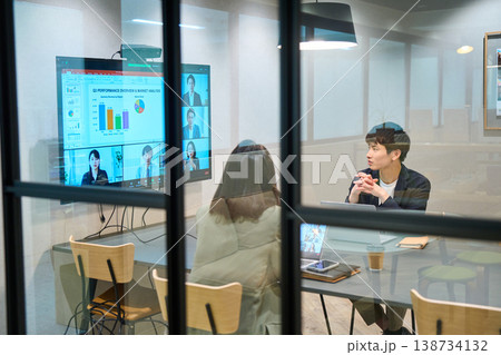 ガラス張りの会議室でリモートチームとWeb会議を行う外資系企業の男女 ガラス張りの会議室でリモートチームとWeb会議を行う外資系企業の男女 138734132