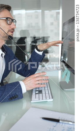 Male call center agent wearing headset providing online customer support, consulting client on headset video call. Business people concept Male call center agent wearing headset providing online customer support, consulting client on headset video call. Business people concept 138734723
