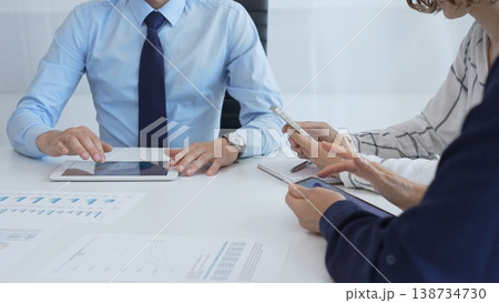 Business team working together, analyzing financial charts and data on digital tablet and smartphones, during a productive meeting in a modern office Business team working together, analyzing financial charts and data on digital tablet and smartphones, during a productive meeting in a modern office 138734730