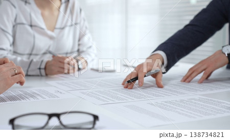 Business partners discussing financial contracts, reviewing legal documentation, and making important decisions at a corporate meeting or during a client consultation Business partners discussing financial contracts, reviewing legal documentation, and making important decisions at a corporate meeting or during a client consultation 138734821