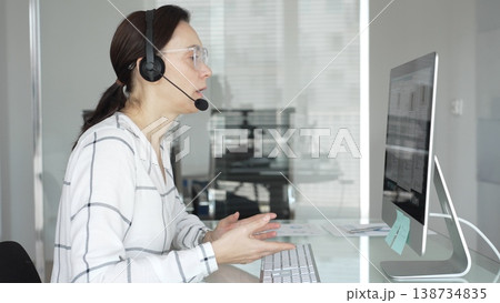 Woman working in call center, providing customer support through headset, communicating in virtual office meeting. Business people concept Woman working in call center, providing customer support through headset, communicating in virtual office meeting. Business people concept 138734835
