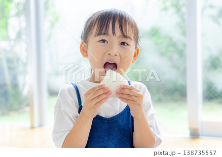 おにぎりを食べる小学生 138735557