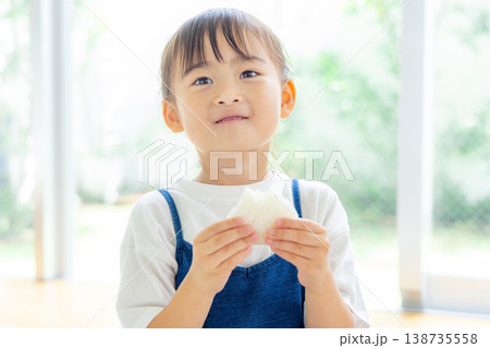 おにぎりを食べる小学生 138735558