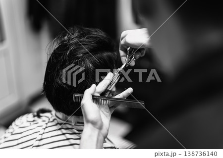 Intimate Barbershop Setting With Skilled Technician Shaping Hair Meticulously In Monochrome Tone 138736140
