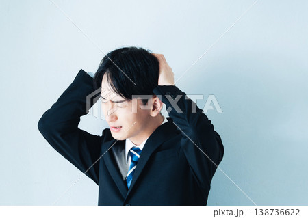 頭を抱えるスーツ姿の若い男性 頭を抱えるスーツ姿の若い男性 138736622