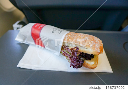 機内食として提供された紙袋に包まれたフランスパン風サンドイッチの先端部分 機内食として提供された紙袋に包まれたフランスパン風サンドイッチの先端部分 138737002