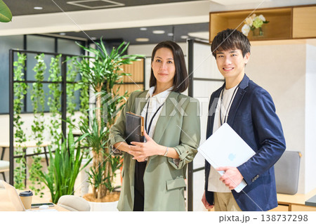緑豊かなオフィスで笑顔を見せる若手男女 138737298