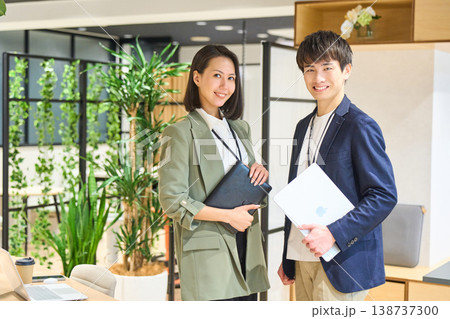 緑豊かなオフィスで笑顔を見せる若手男女 緑豊かなオフィスで笑顔を見せる若手男女 138737300
