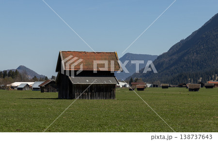 Traditional Wooden Barn in Open Meadow with Alpine Valley Background Traditional Wooden Barn in Open Meadow with Alpine Valley Background 138737643