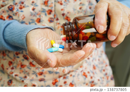 Asian elderly woman holding pill drug in hand, strong healthy medical. Asian elderly woman holding pill drug in hand, strong healthy medical. 138737805