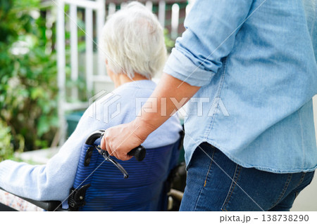 Caregiver help Asian elderly woman disability patient sitting on wheelchair in hospital. 138738290