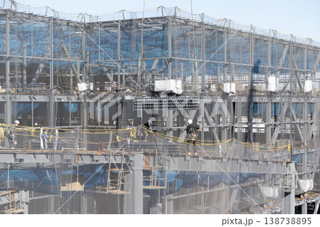 建設現場でクレーンで吊り上げられた床材を誘導しながら着地作業を行う作業員1 138738895