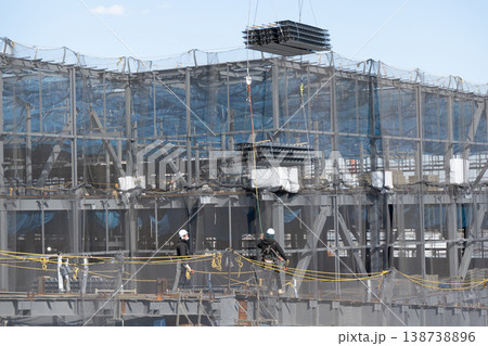 建設現場でクレーンで吊り上げられた床材を誘導しながら着地作業を行う作業員2 138738896