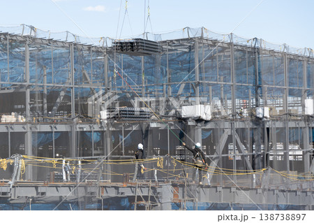 建設現場でクレーンで吊り上げられた床材を誘導しながら着地作業を行う作業員3 138738897