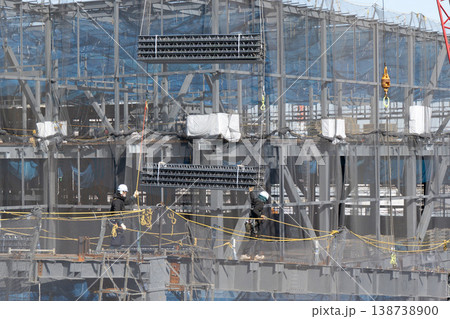 建設現場でクレーンで吊り上げられた床材を誘導しながら着地作業を行う作業員6 138738900