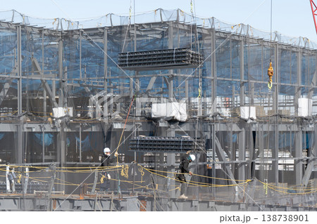 建設現場でクレーンで吊り上げられた床材を誘導しながら着地作業を行う作業員7 138738901