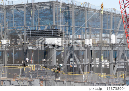 建設現場でクレーンで吊り上げられた床材を誘導しながら着地作業を行う作業員10 138738904