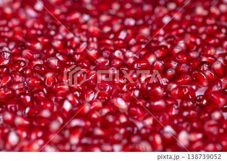 Bright pomegranate seeds dense abstract pattern repeating glossy arils filling frame, macro texture study, vibrant red palette, minimal composition, artistic background 138739052