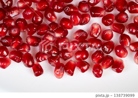 Pomegranate seeds on white background. Fresh arils displayed against plain white surface. Isolated pomegranate seeds emphasizing juicy texture and vibrant color Pomegranate seeds on white background. Fresh arils displayed against plain white surface. Isolated pomegranate seeds emphasizing juicy texture and vibrant color 138739099