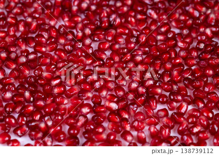 Bright pomegranate seeds scattered across surface, sparkling red arils evoke holiday romance and luxury, mood lighting adds sensual shimmer for seasonal campaigns Bright pomegranate seeds scattered across surface, sparkling red arils evoke holiday romance and luxury, mood lighting adds sensual shimmer for seasonal campaigns 138739112