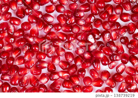 Bright pomegranate seeds scattered on white, highcontrast macro shot showing translucent ruby arils, glossy highlights and detailed texture for food backgrounds and packaging Bright pomegranate seeds scattered on white, highcontrast macro shot showing translucent ruby arils, glossy highlights and detailed texture for food backgrounds and packaging 138739219