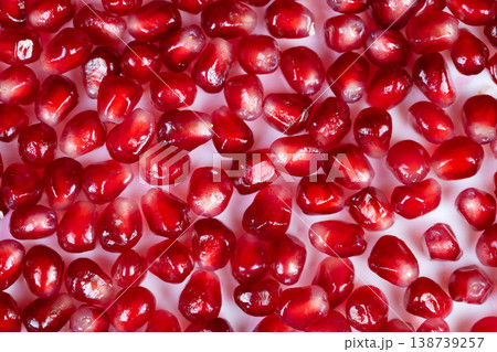 Highcontrast studio shot emphasizing illuminated reddish fruit interiors. Macro image capturing translucent pomegranate seeds with reflective gloss and vibrant coloration Highcontrast studio shot emphasizing illuminated reddish fruit interiors. Macro image capturing translucent pomegranate seeds with reflective gloss and vibrant coloration 138739257