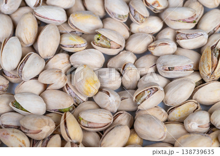 Close up cluster of pistachio kernels, vibrant green nut meat visible through pale shells, proteinrich snack mood, clean lighting for wellness and nutrition content Close up cluster of pistachio kernels, vibrant green nut meat visible through pale shells, proteinrich snack mood, clean lighting for wellness and nutrition content 138739635