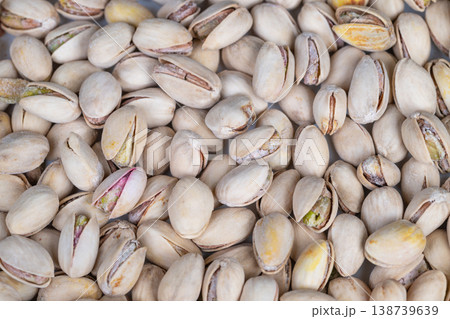 Pistachios with shadows. Detailed view of pistachios highlighting subtle shades and shadows. Detailed shot of pistachios emphasizing natural hues and soft shadow play Pistachios with shadows. Detailed view of pistachios highlighting subtle shades and shadows. Detailed shot of pistachios emphasizing natural hues and soft shadow play 138739639