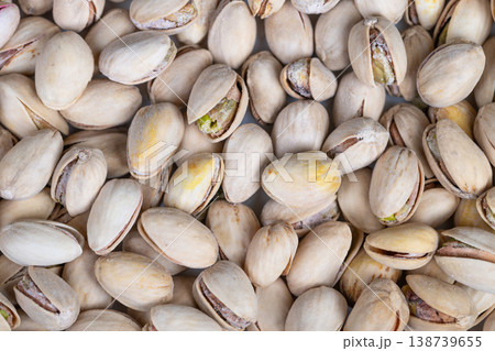 Green nut visuals. Detailed cracked pistachio shells surrounding vivid green kernels. Closeup of vibrant pistachio shells showing intricate cracks and fresh green kernels Green nut visuals. Detailed cracked pistachio shells surrounding vivid green kernels. Closeup of vibrant pistachio shells showing intricate cracks and fresh green kernels 138739655