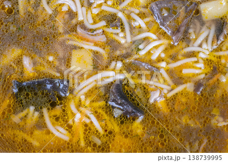 Rich broth with mushrooms and herbs. Creamy mushroom broth topped with herbs and noodles. Refined presentation of savory mushroom soup adorned with herbs and delicate noodles 138739995